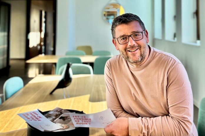 Smiling man sitting at table with cards.