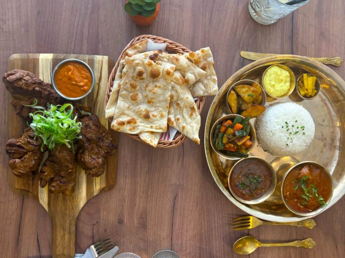 Plat indien avec curry, riz, légumes et naan.