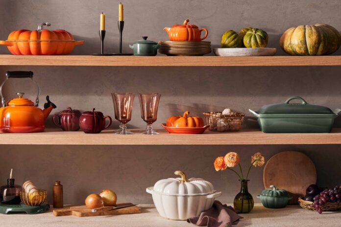 Autumn-themed kitchenware and decorations on wooden shelves.