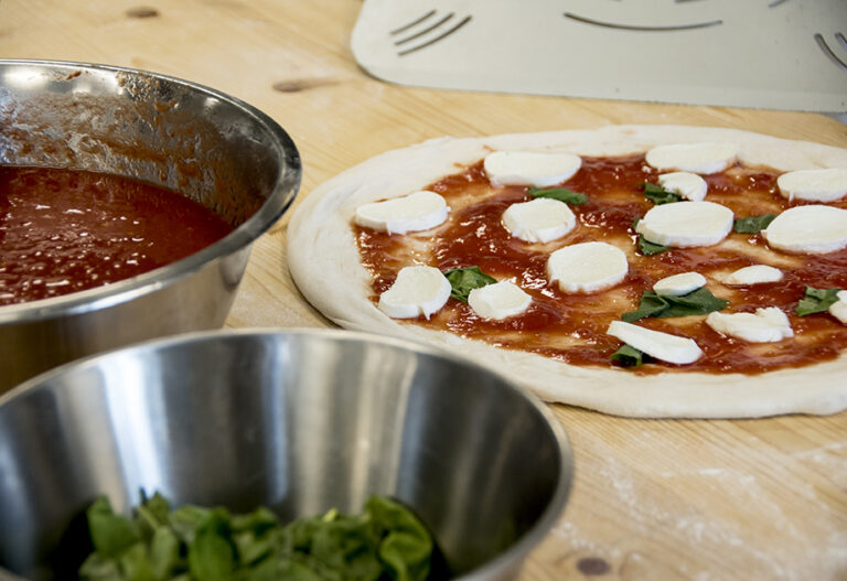 Unbaked pizza with tomato sauce and mozzarella