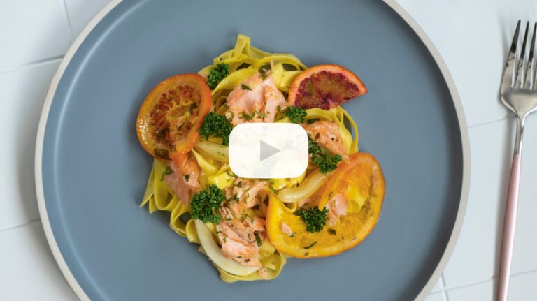 Pasta with oven baked salmon on citrus fruits
