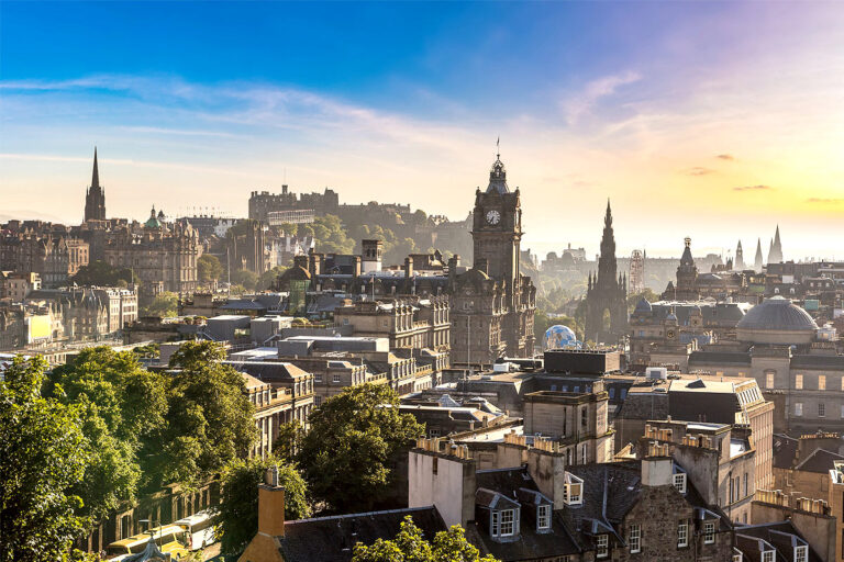 Panoramic view of Edinburgh cityscape at sunrise.