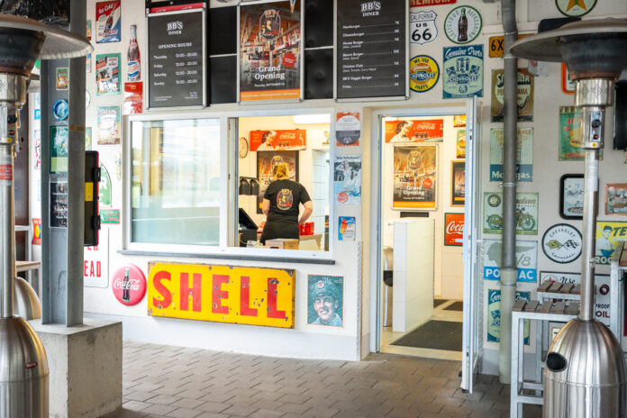 Retro diner with vintage signs and menu boards.