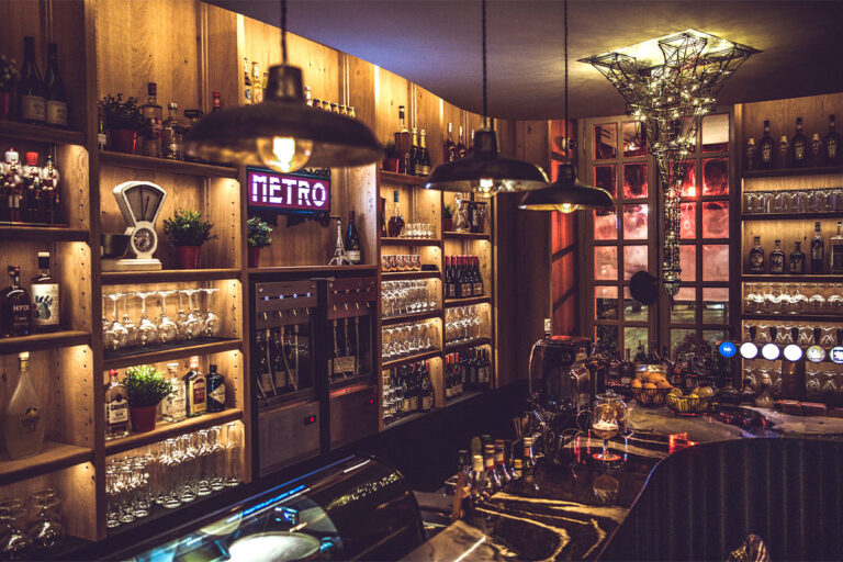 Cozy wooden bar interior with wine display.