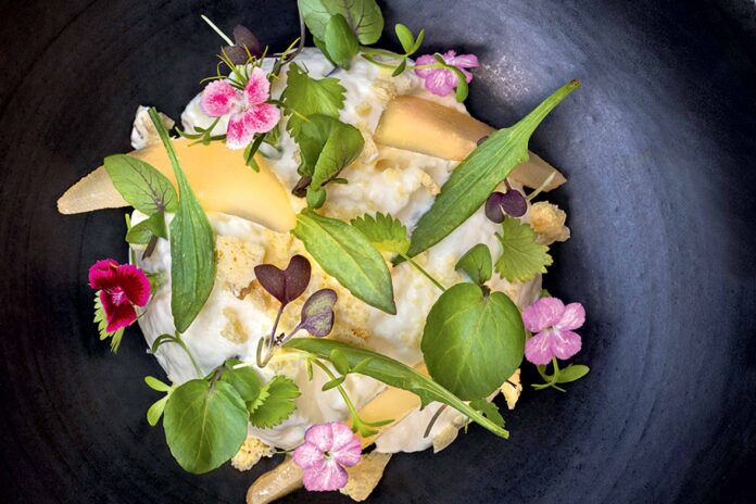 Gourmet dish with edible flowers and greens