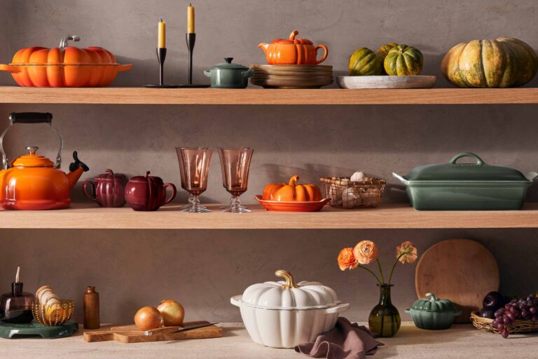 Autumn-themed kitchenware and decorations on wooden shelves.
