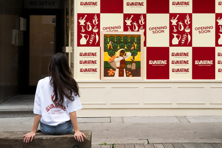 Woman in front of Levantine restaurant opening soon.