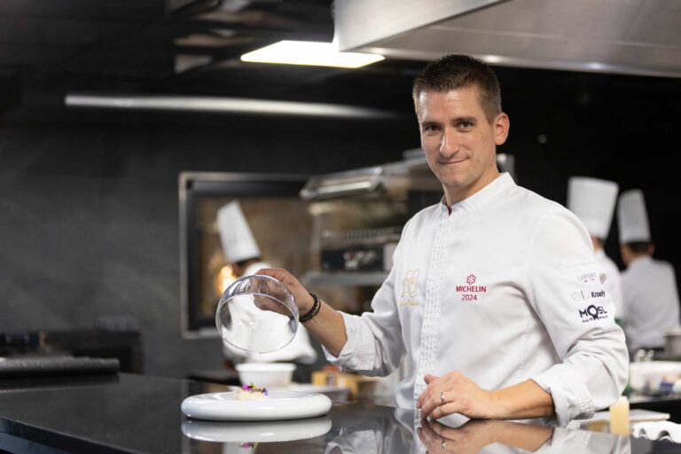 Chef preparing dish in kitchen.