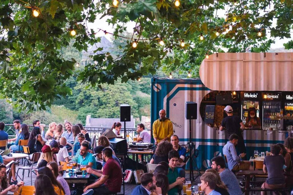 Outdoor bar with people enjoying drinks and music.