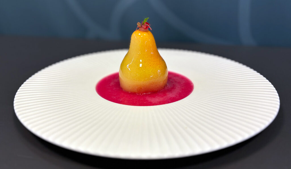 Gourmet poached pear with raspberry sauce.