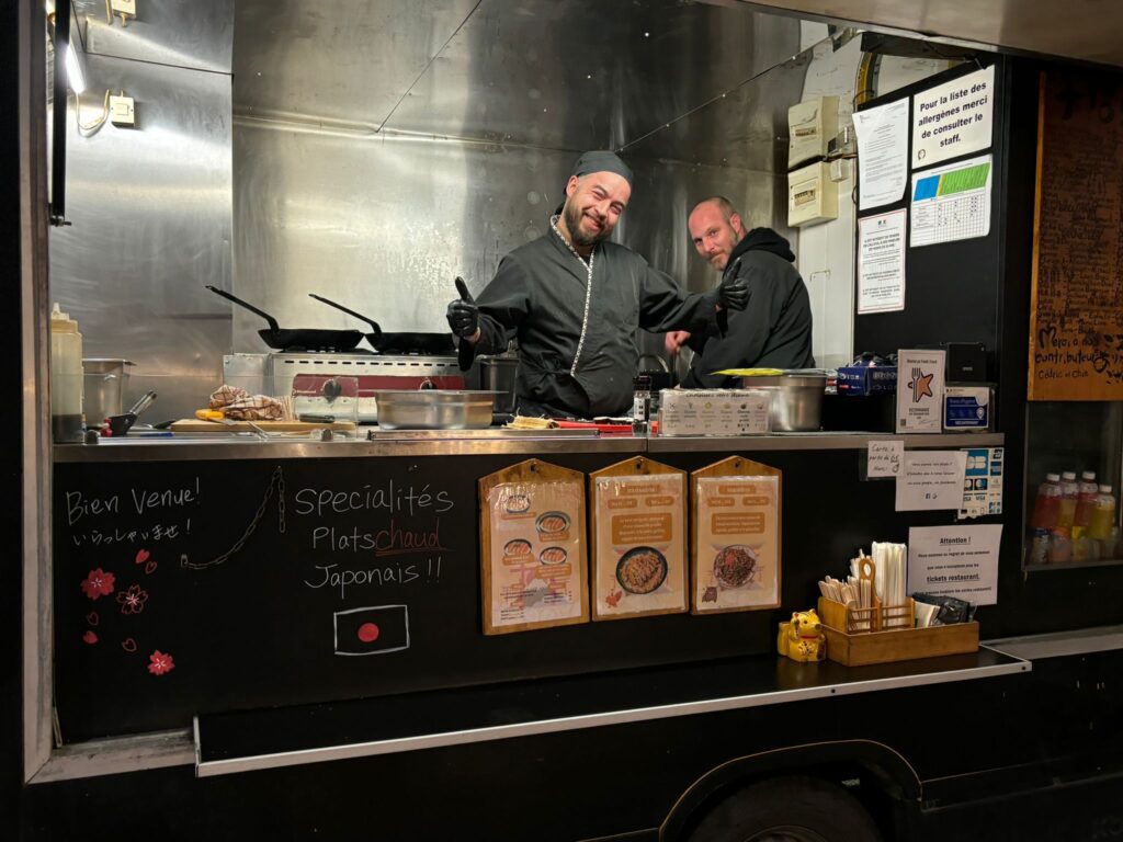 Two chefs in a Japanese food truck kitchen.