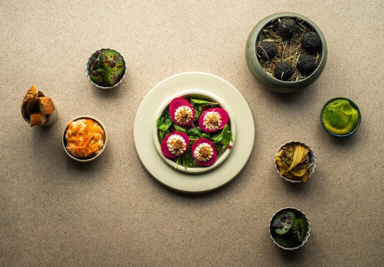 Gourmet dish with colorful appetizers and garnishes.