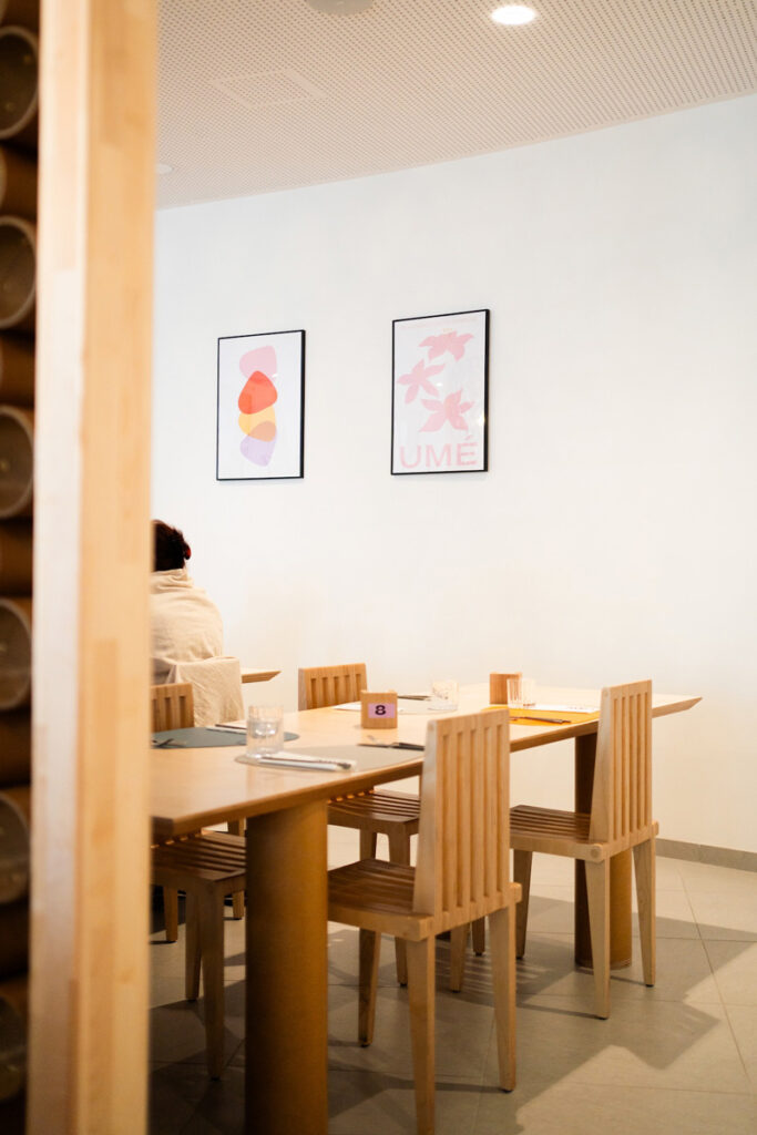 Minimalist dining area with wooden chairs and tables.