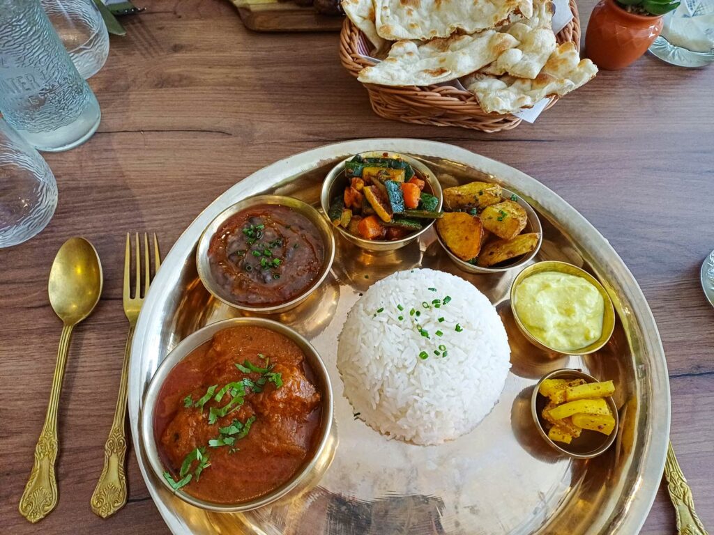 Thali indien avec riz, curry, légumes, naan.