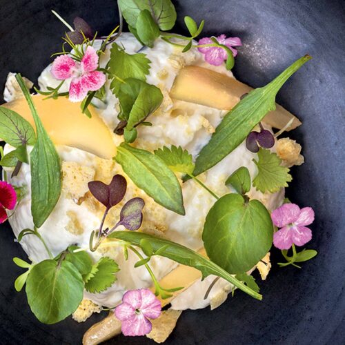 Gourmet dish with edible flowers and greens