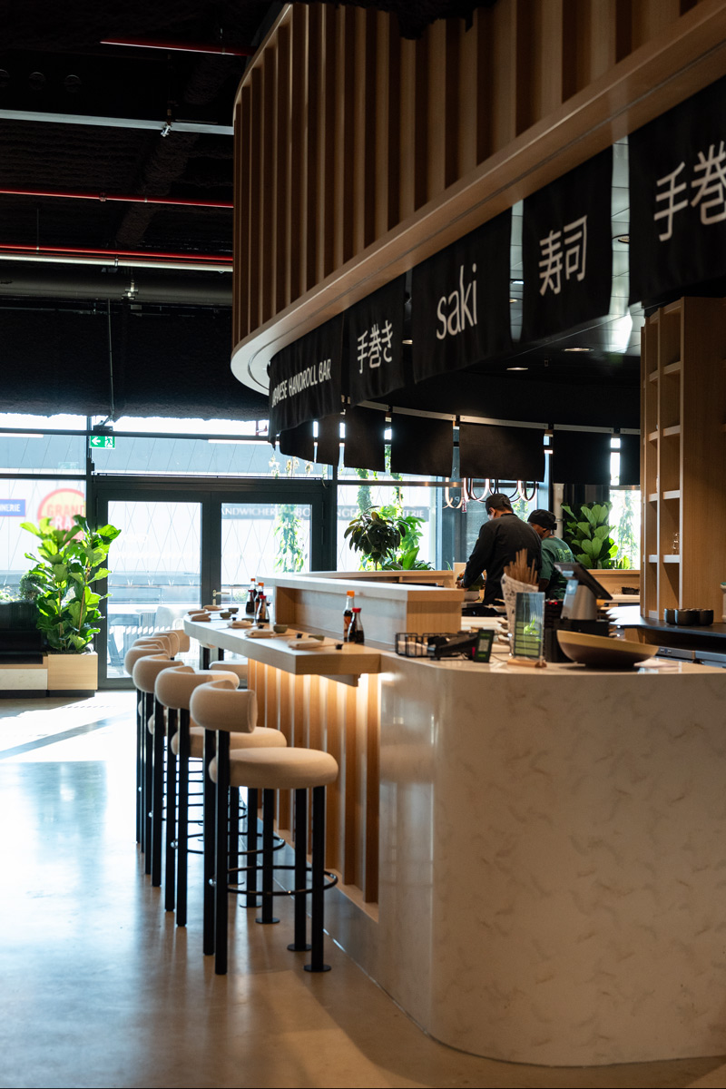 Modern Japanese sushi bar with stools and decor.