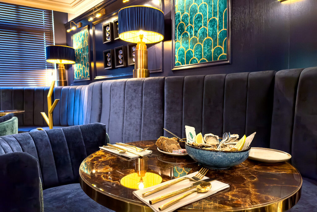 Luxury restaurant interior with velvet seating and table.