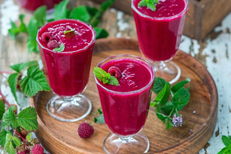 Glasses of fresh raspberry smoothie with mint leaves.