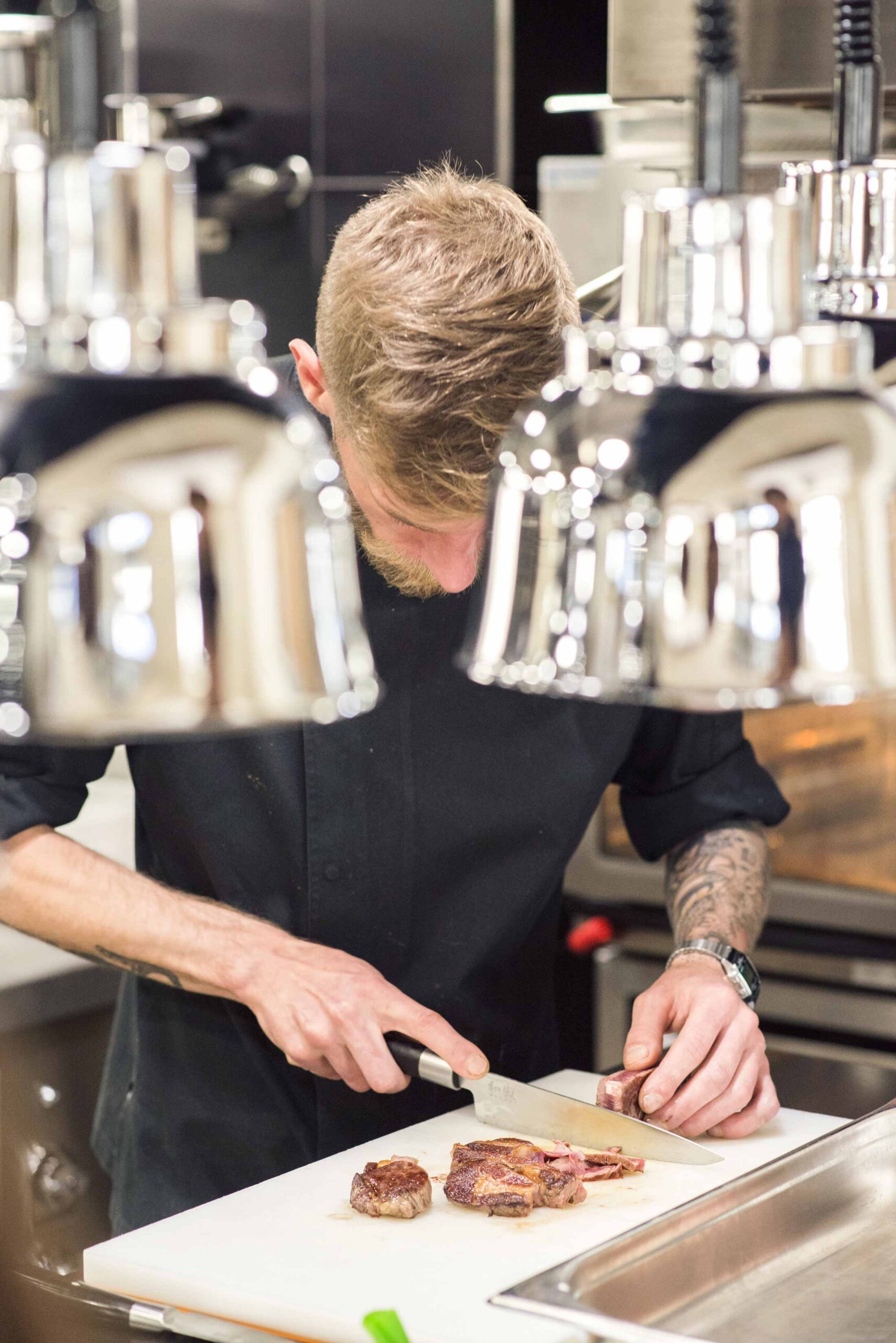 Chef slicing steak in kitchen