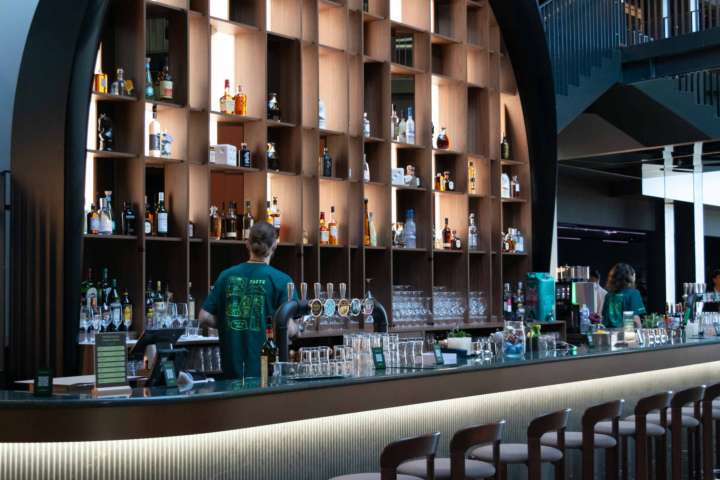 Modern bar with shelves of liquor bottles.