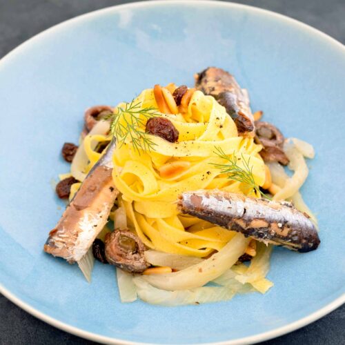 Pasta with sardines, dried fruits, and herbs.