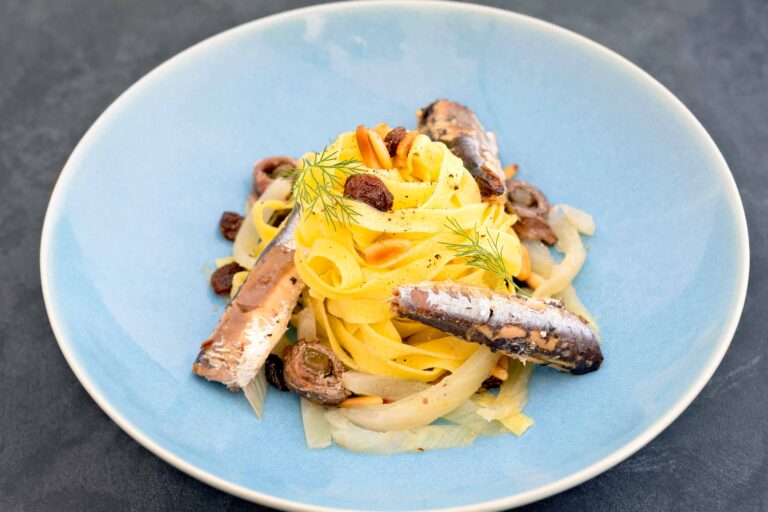 Pasta with sardines, dried fruits, and herbs.