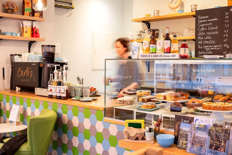 Cozy cafe interior with coffee and pastries display.