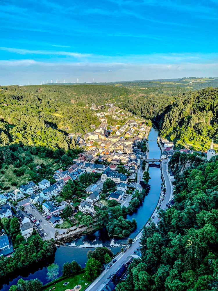 Aerial view of town with river and forest.