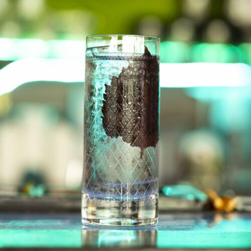 Tall glass with decorative design on table