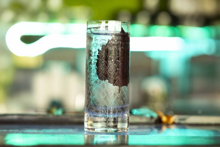 Tall glass with decorative design on table
