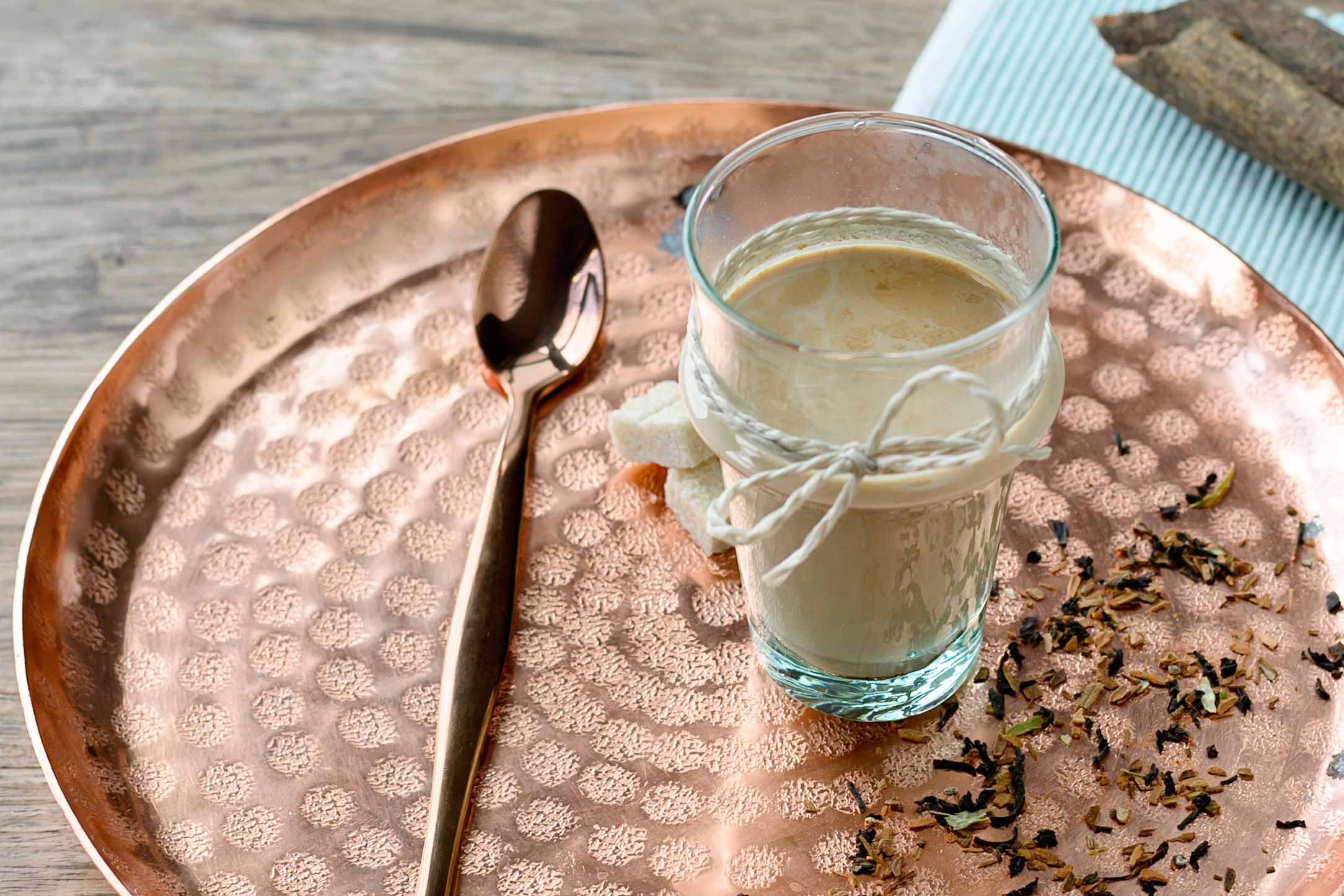 Licorice tea in a glass on copper tray.